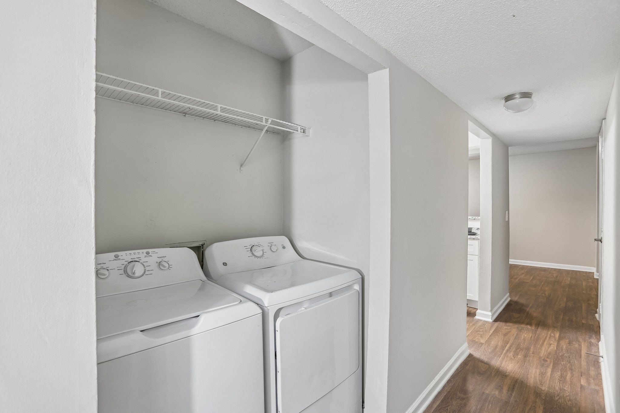 Two white front load washing machines in a laundry room.